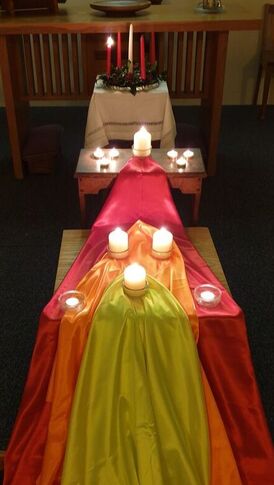 A visual focus of candles on coloured cloth representing a flame.
